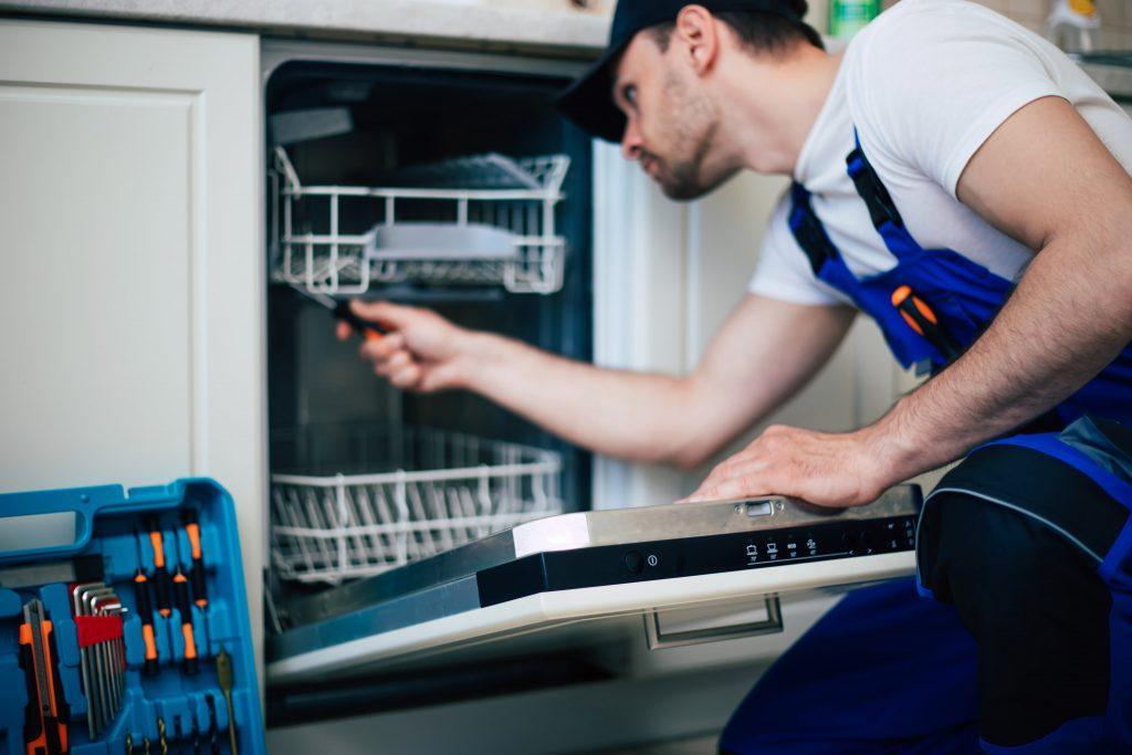 A man repairing a dishwasher
